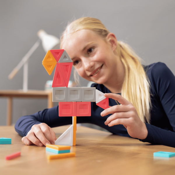 Fetiță construind un model din setul de construcție magnetic Connetix PRO