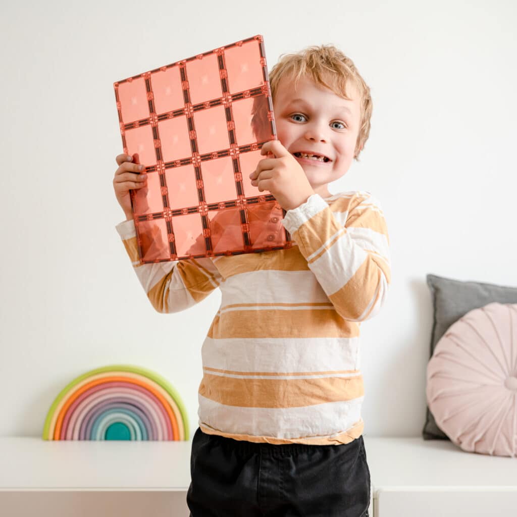 Un copil ține o placă magnetică mare Connetix 30 × 30 cm